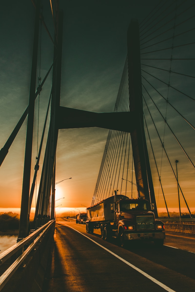 brown Maek freight truck on bridge during dawn with trucking insurance